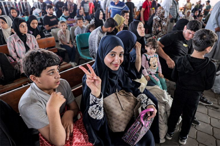 People sit in the waiting area at the Rafah border crossing