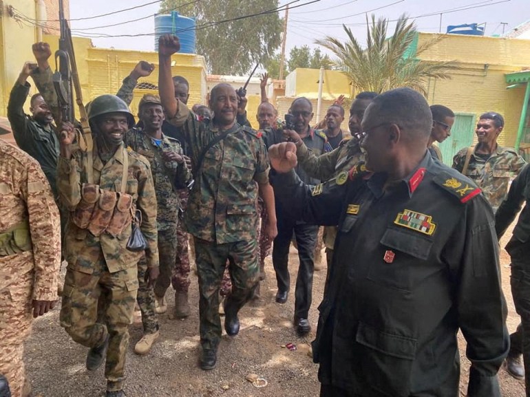 Sudan's General Abdel Fattah al-Burhan walks with troops,in an unknown location, in this picture released on May 30, 2023