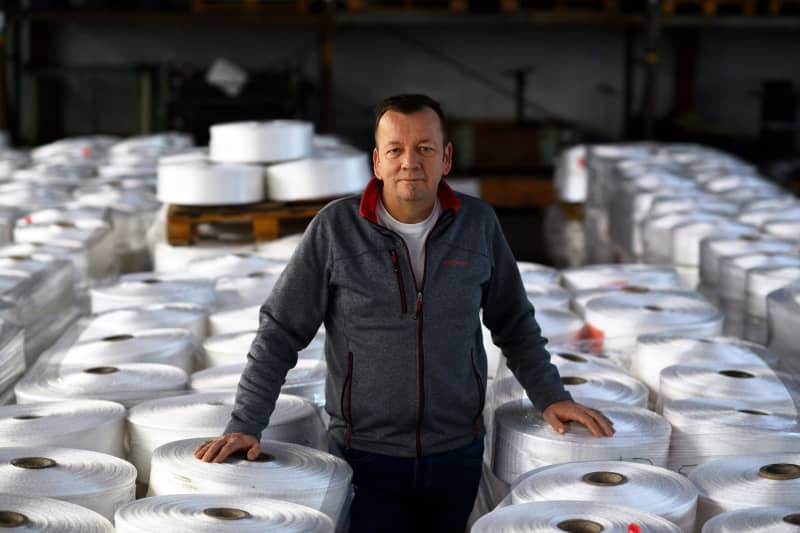 Thomas Hartung, managing director of Mesh Pack, stands in the warehouse between countless rolls of tubular nets. Klaus-Dietmar Gabbert/dpa