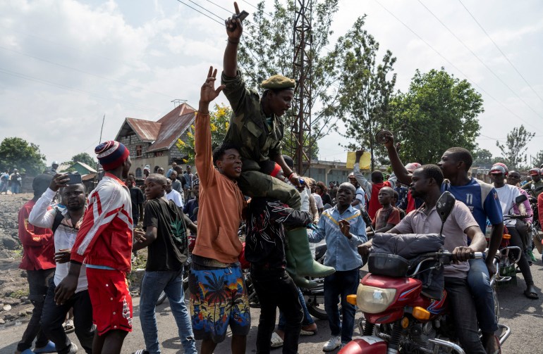 Activists lift an supporter of the VDP wazalendo during a demonstration calling for an end to the fighting between the M23 rebels and the Congolese army and denouncing the international community's silence on the conflicts in Goma, North Kivu