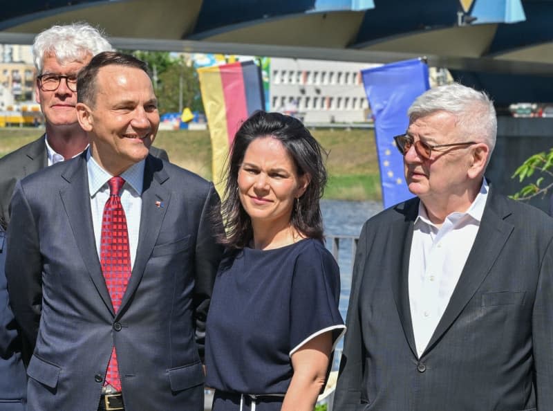 (L-R) Radoslaw Sikorski, Foreign Minister of Poland, Annalena Baerbock, Foreign Minister of Germany, and Joschka Fischer, former Foreign Minister of Germany, stand in front of the city bridge between the twin city of Frankfurt (Oder) and the Polish city of Slubice on the 20th anniversary of Poland's accession to the EU. Patrick Pleul/dpa