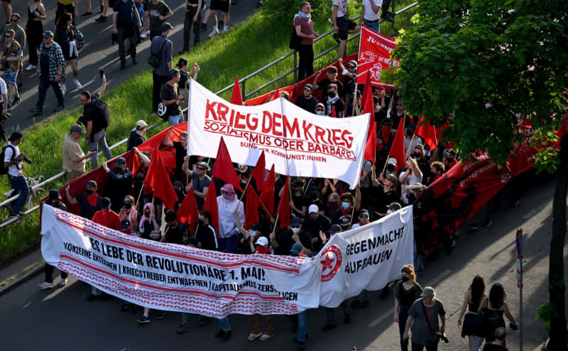 People hold up a banner with the words "War on War" during the "Revolutionary May Day Demonstration". Sebastian Gollnow/dpa